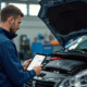 Mecanicien utilisant une tablette diagnostic à côté d'une Peugeot 1,6 HDi ouverte