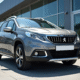 Peugeot 2008 gris métallique devant un concessionnaire